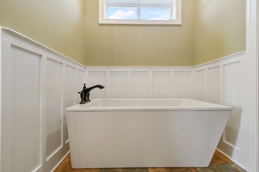 white bathtub with black faucet and knobs