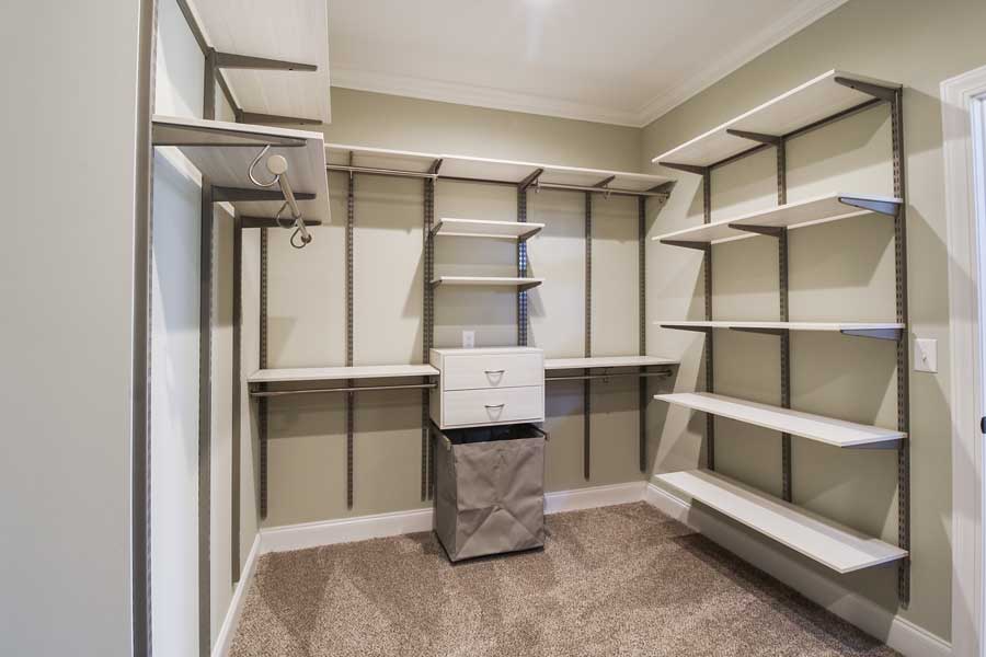master closet with shelving and cabinets