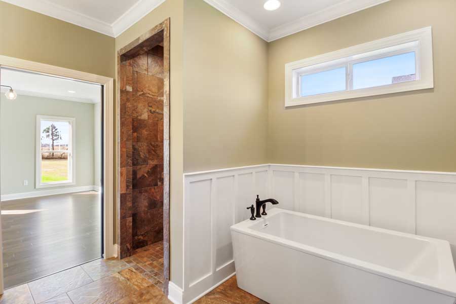 white bathtub with white trim and tan paint